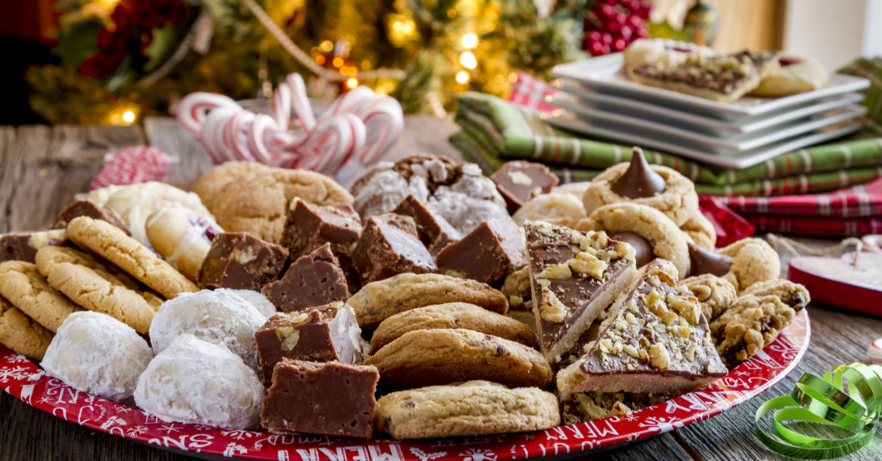 A plate of holiday treats in front of a Christmas tree. A plate of holiday treats in front of a Christmas tree.