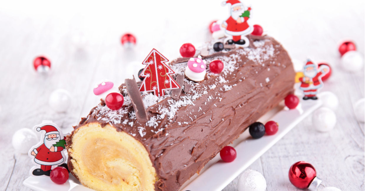 A bûche de Noël or a yule log decorated with Santas. A bûche de Noël or a yule log decorated with Santas.