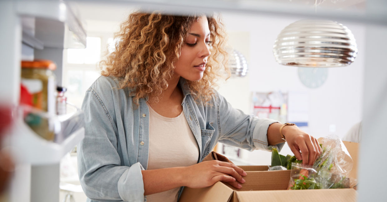 Woman carefully unpacks home food delivery Woman carefully unpacks home food delivery