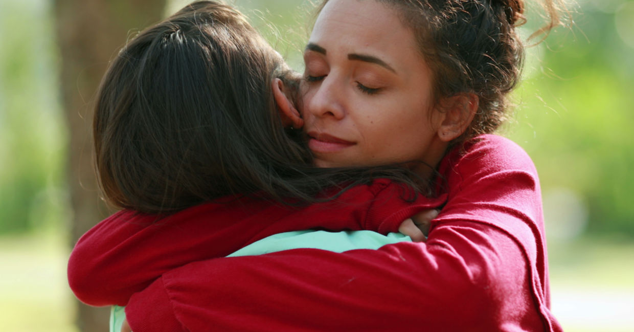 A woman shows forgiveness by embracing a family member. A woman shows forgiveness by embracing a family member.