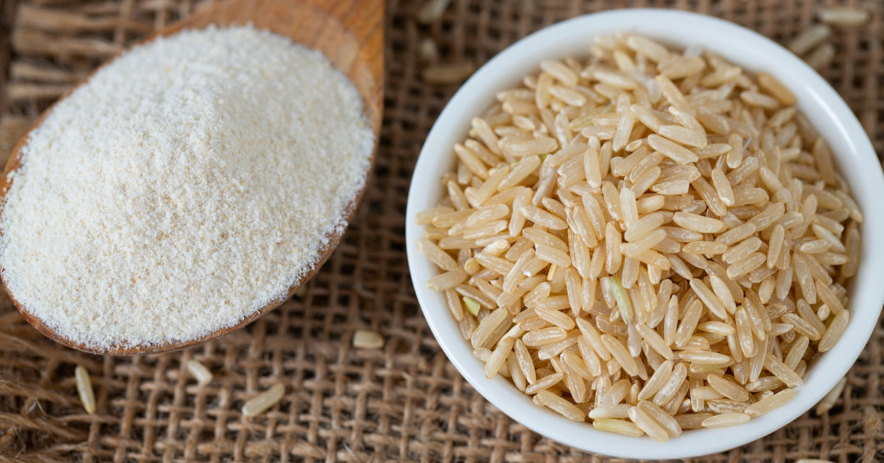 A spoonful of gluten free brown rice flour rice set beside a bowl of brown rice. A spoonful of gluten free brown rice flour rice set beside a bowl of brown rice.
