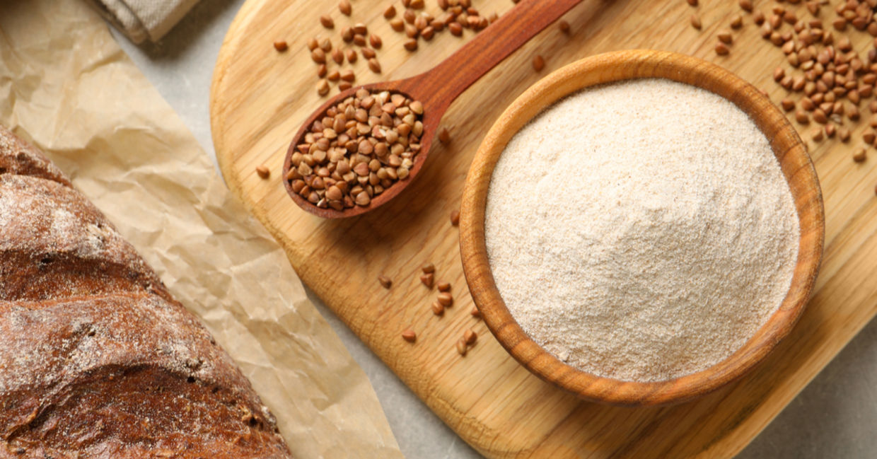 Buckwheat kernels and buckwheat flour beside a freshly baked loaf of gluten-free bread. Buckwheat kernels and buckwheat flour beside a freshly baked loaf of gluten-free bread.