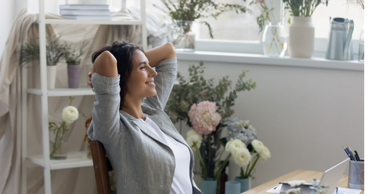 A woman feels calm and relaxed in her mindful workspace surrounded by flowers and soft colors. A woman feels calm and relaxed in her mindful workspace surrounded by flowers and soft colors.