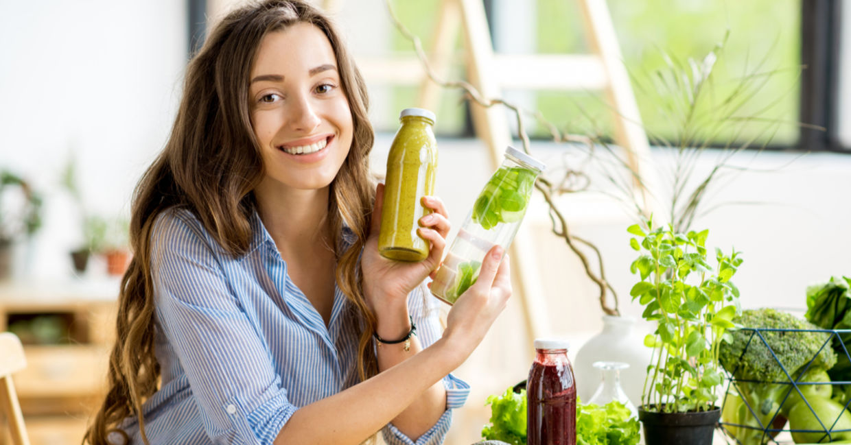 A woman doing a detox shows her healthy smoothies along with detoxifying fruits and vegetables. A woman doing a detox shows her healthy smoothies along with detoxifying fruits and vegetables.