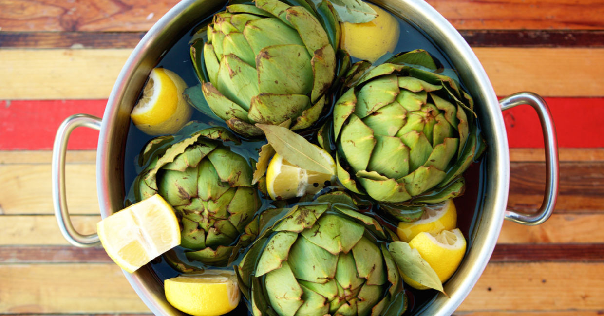 Fresh artichokes and lemons in a pot. Fresh artichokes and lemons in a pot.
