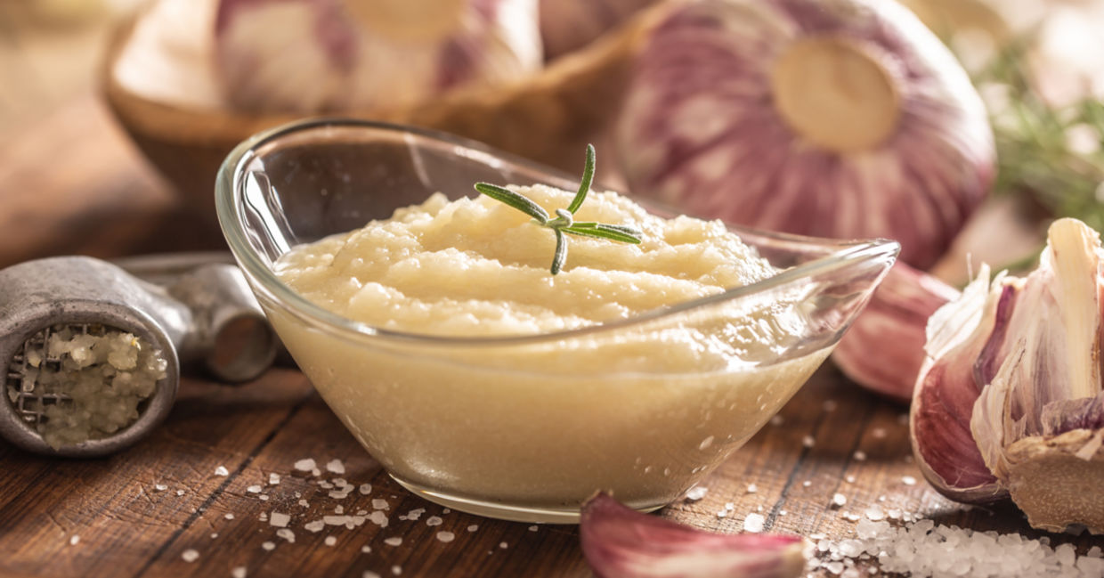 Garlic paste in a bowl with garlic cloves and sea salt. Garlic paste in a bowl with garlic cloves and sea salt.