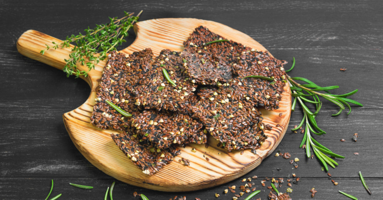 Freshly made flaxseed crackers with sprigs of fresh rosemary. Freshly made flaxseed crackers with sprigs of fresh rosemary.