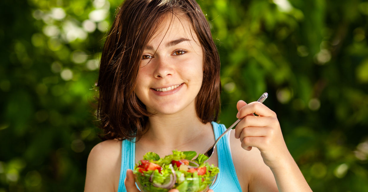 Girl eating fresh vegetable salad. Girl eating fresh vegetable salad.