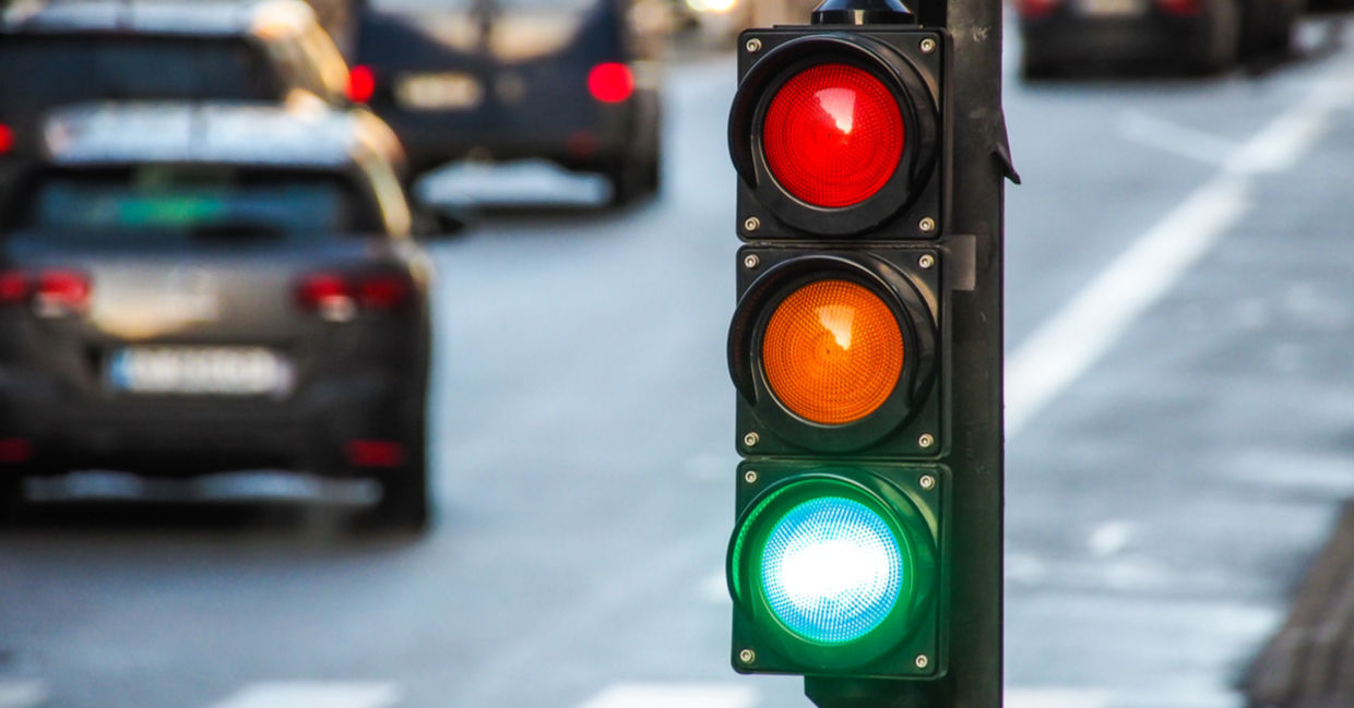 A traffic light, pedestrian crossing, and cars at a busy intersection. A traffic light, pedestrian crossing, and cars at a busy intersection.