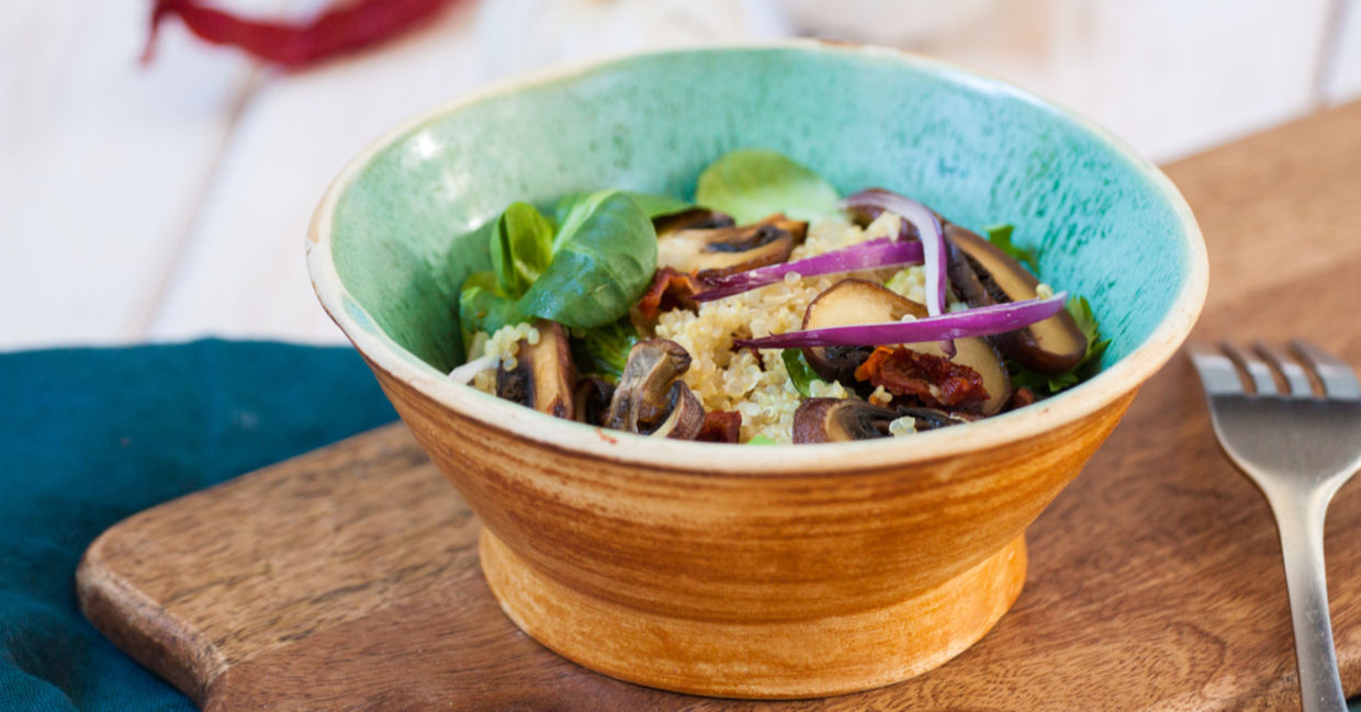Blue bowl filled with fresh homemade salad with quinoa, spinach and mushrooms. Blue bowl filled with fresh homemade salad with quinoa, spinach and mushrooms.
