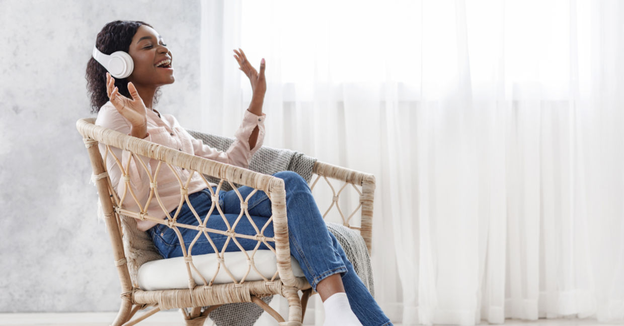 A woman sits in a chair enjoying listening to music. A woman sits in a chair enjoying listening to music.