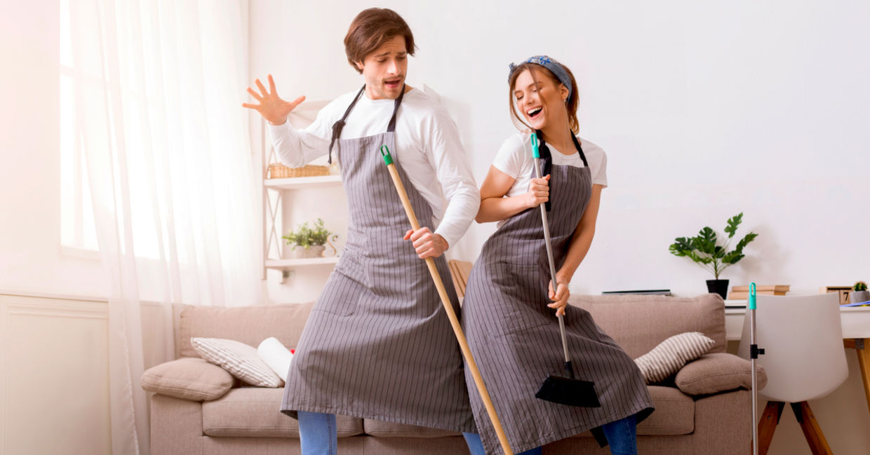 Cheerful couple having fun and dancing while spring cleaning their home. Cheerful couple having fun and dancing while spring cleaning their home.