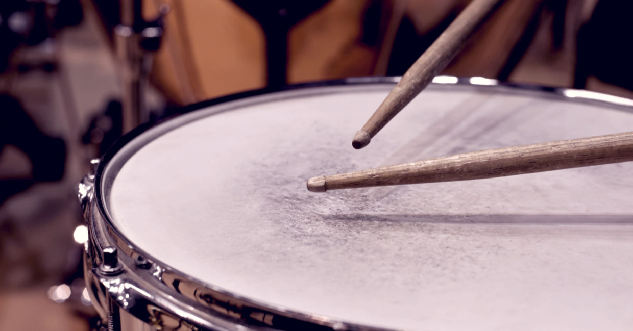 Close-up of drumsticks hitting a drum. Close-up of drumsticks hitting a drum.