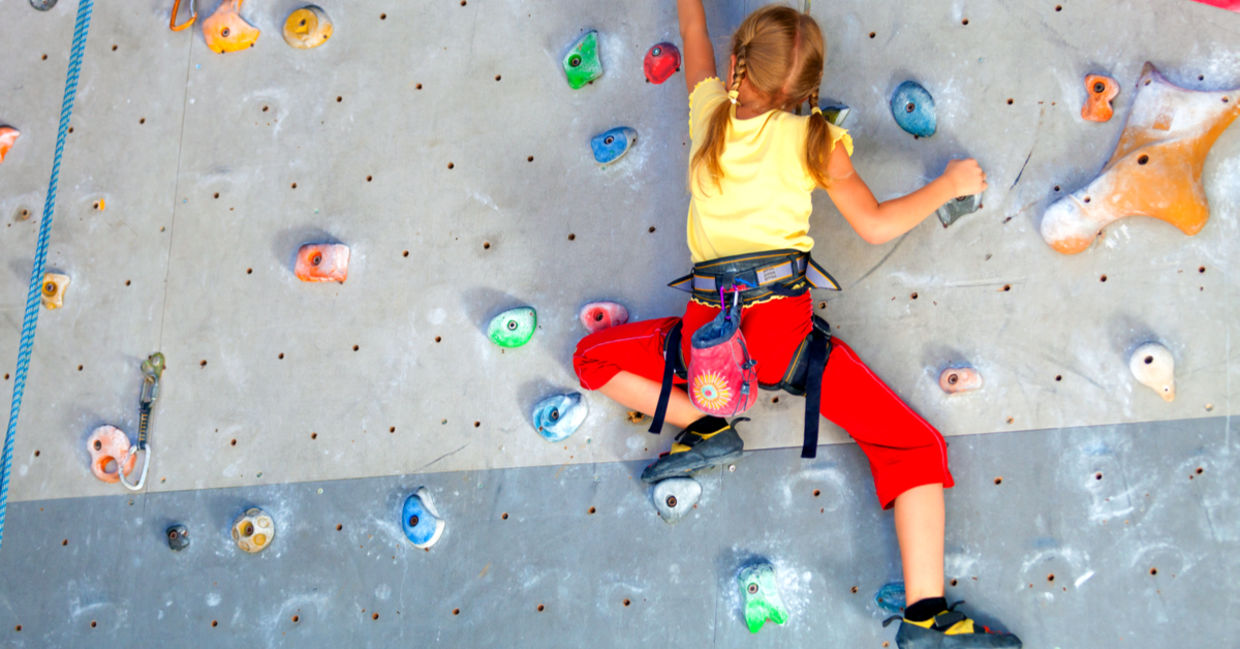 Girl climbing a rock indoor wall. Girl climbing a rock indoor wall.