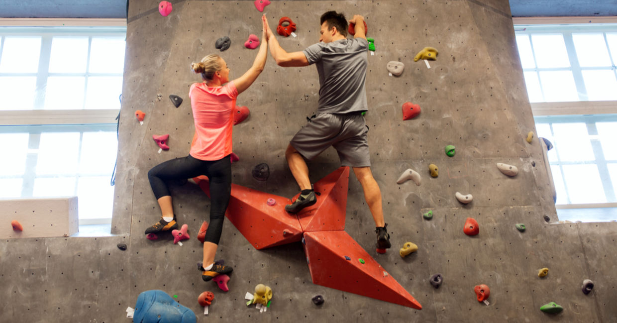 Indoor rock climbers making a high five gesture. Indoor rock climbers making a high five gesture.