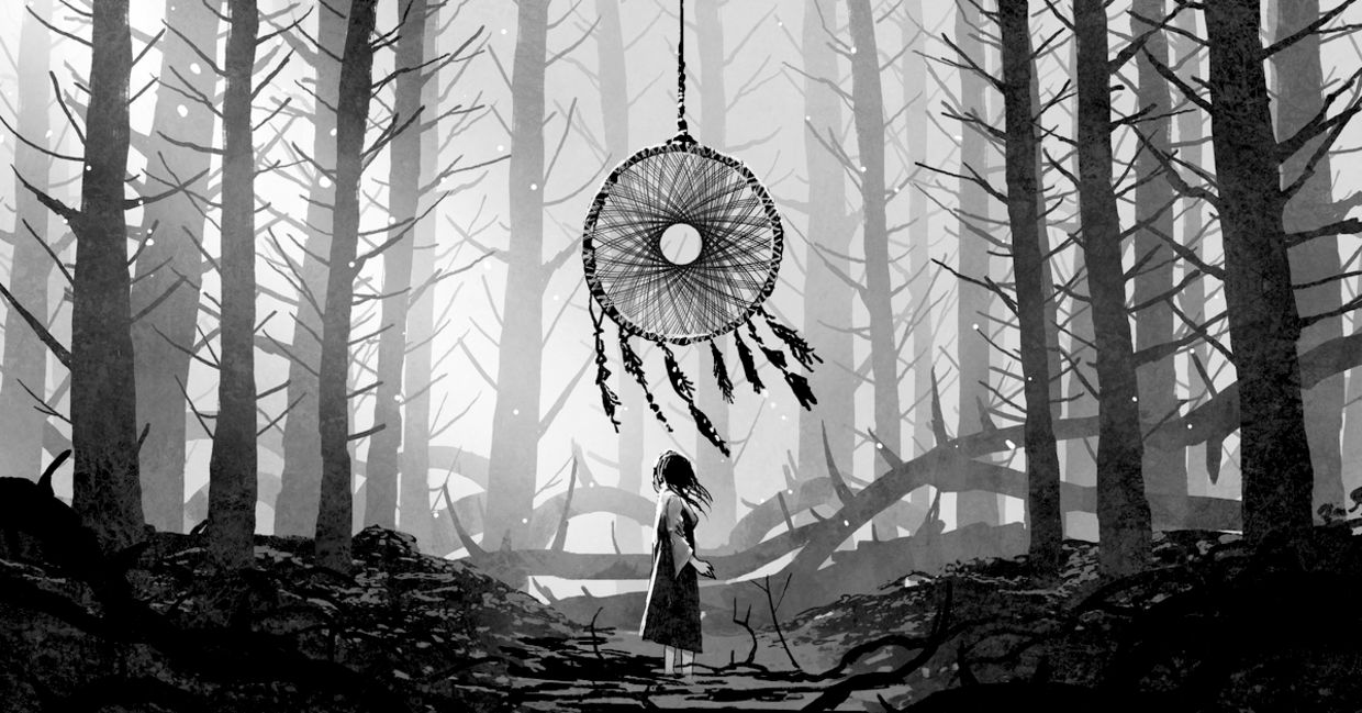 Woman standing and looking at a dreamcatcher hanging from the trees in a forest. Woman standing and looking at a dreamcatcher hanging from the trees in a forest.