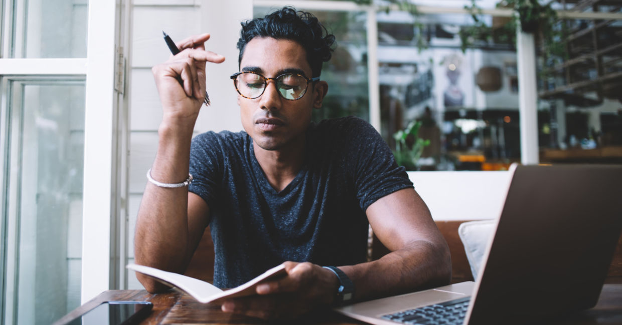 Concentrated man thinking and taking notes in a cafe. Concentrated man thinking and taking notes in a cafe.