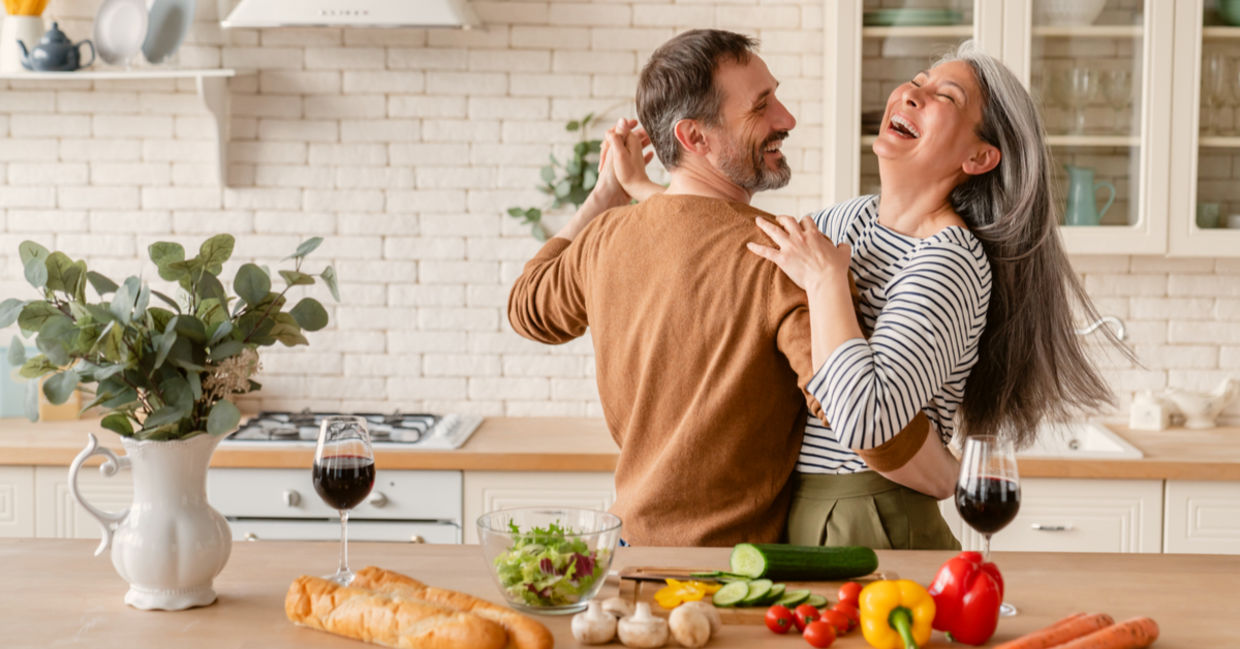 Happy couple dancing together in the kitchen while cooking. Happy couple dancing together in the kitchen while cooking.