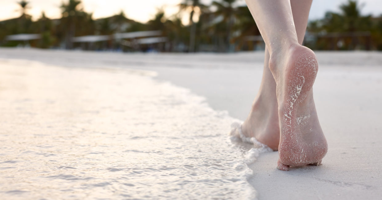 As a woman strolls on the beach, her body enjoys a gentle workout. As a woman strolls on the beach, her body enjoys a gentle workout.
