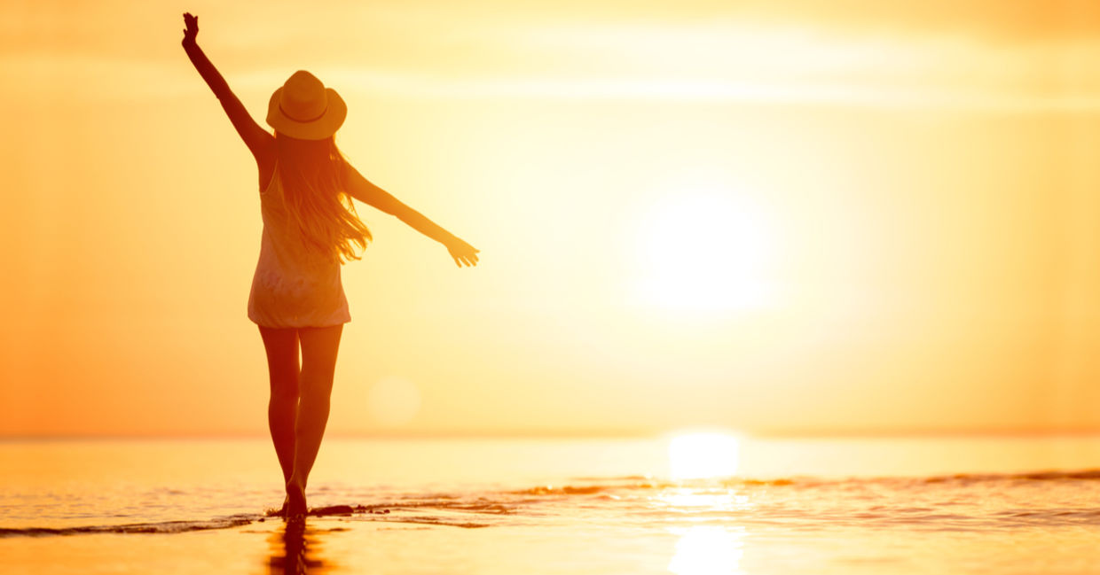 A woman enjoys a relaxing sunset stroll along the beach. A woman enjoys a relaxing sunset stroll along the beach.