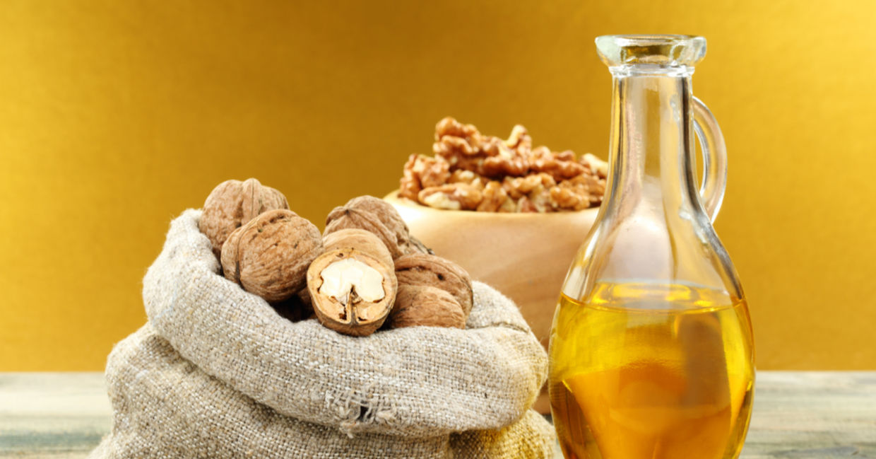Walnut oil beside raw walnuts. Walnut oil beside raw walnuts.