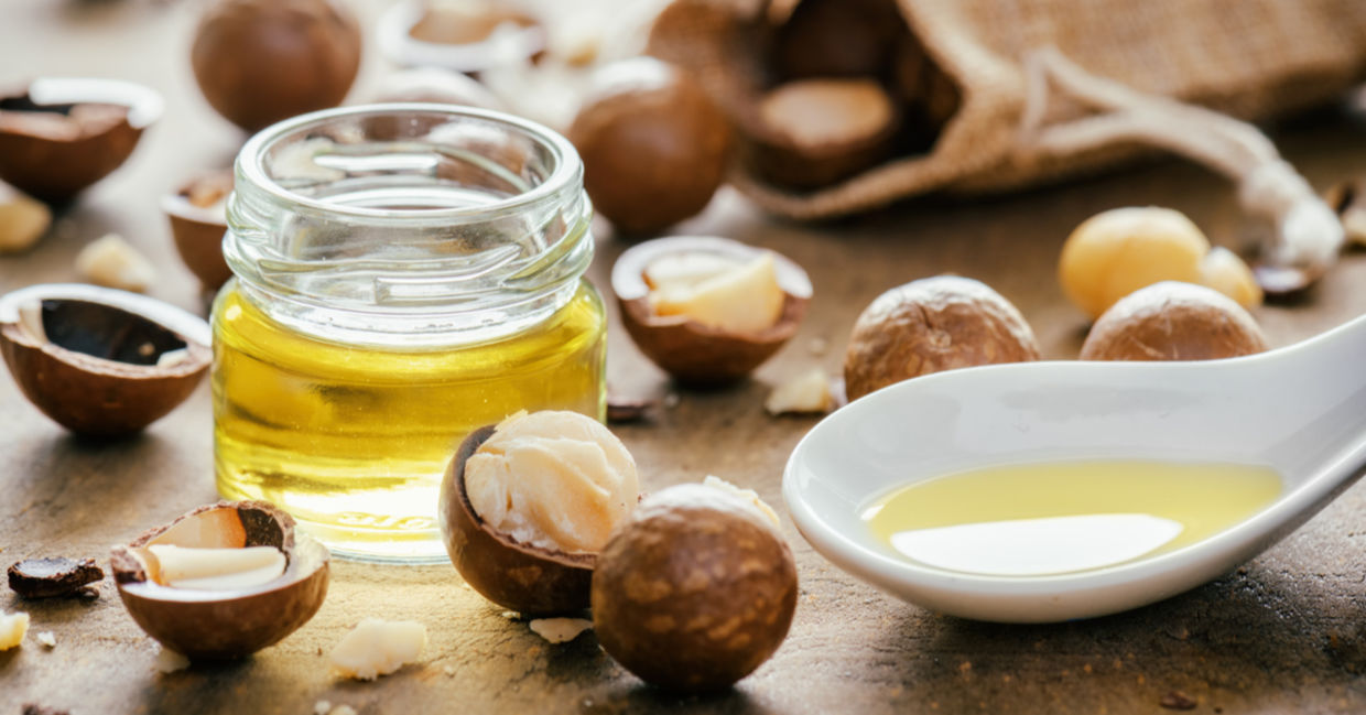 Macadamia nuts beside a bottle of healthy macadamia oil. Macadamia nuts beside a bottle of healthy macadamia oil.