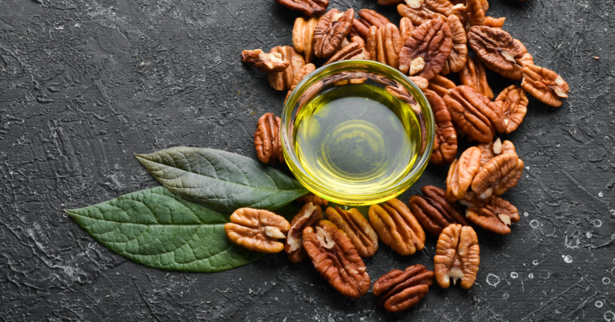 Fresh, raw pecans and a bottle of pecan oil. Fresh, raw pecans and a bottle of pecan oil.
