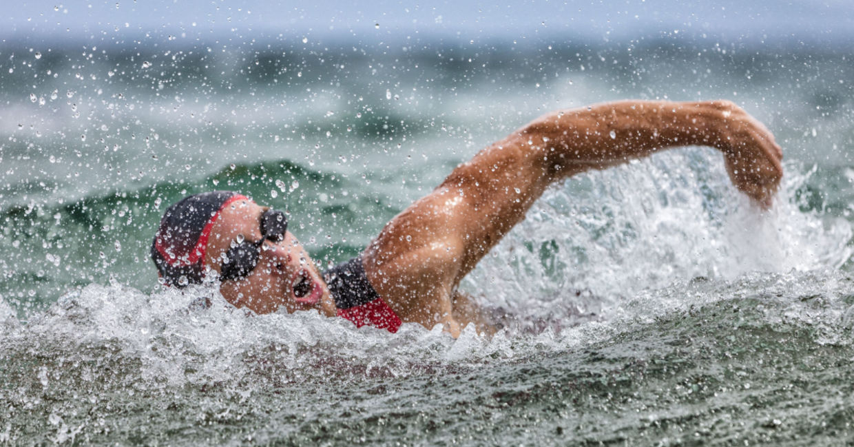 Swimmer in ocean waves wearing a swim cap. Swimmer in ocean waves wearing a swim cap.