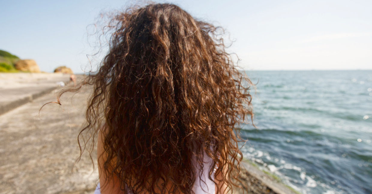 Young woman with long hair at the beach. Young woman with long hair at the beach.