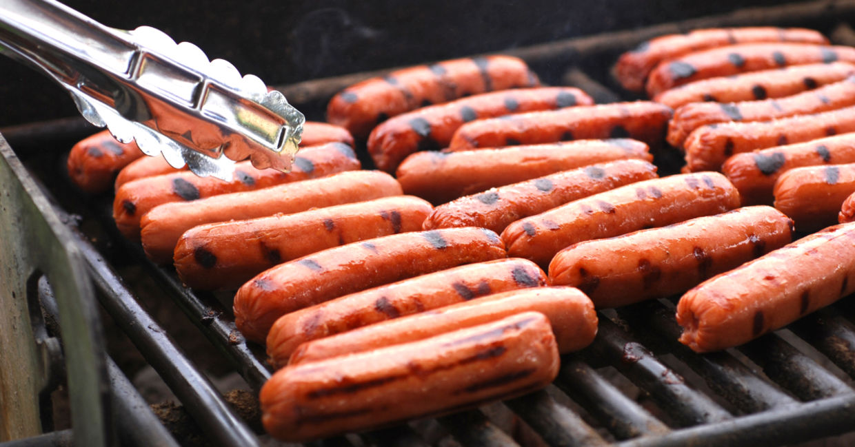 Hot dogs sizzling on a grill. Hot dogs sizzling on a grill.