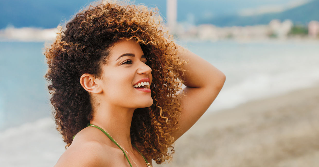 Woman with curly hair enjoying the beach. Woman with curly hair enjoying the beach.