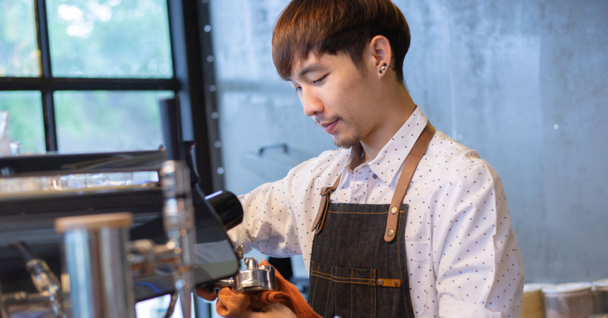 Barista at work cleaning equipment in a café. Barista at work cleaning equipment in a café.