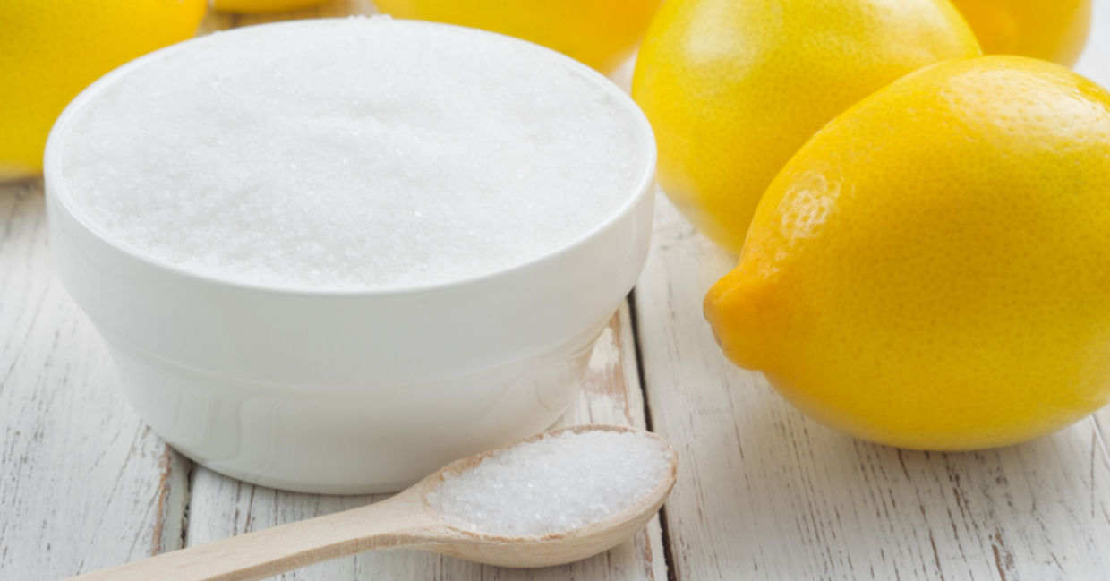 A bowl of citric acid beside lemons. A bowl of citric acid beside lemons.