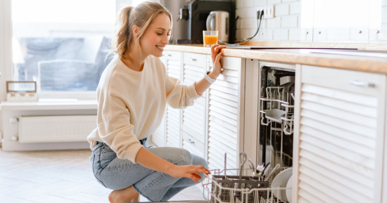 A woman uses citric acid to make the inside of her dishwasher shine. A woman uses citric acid to make the inside of her dishwasher shine.