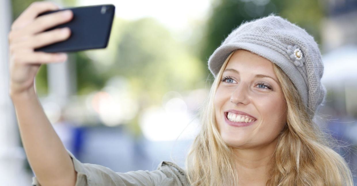 A young woman smiles as she poses for a selfie. A young woman smiles as she poses for a selfie.