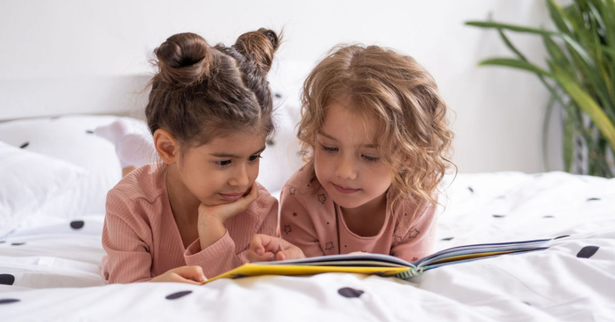 Two sisters reading a book before bedtime. Two sisters reading a book before bedtime.