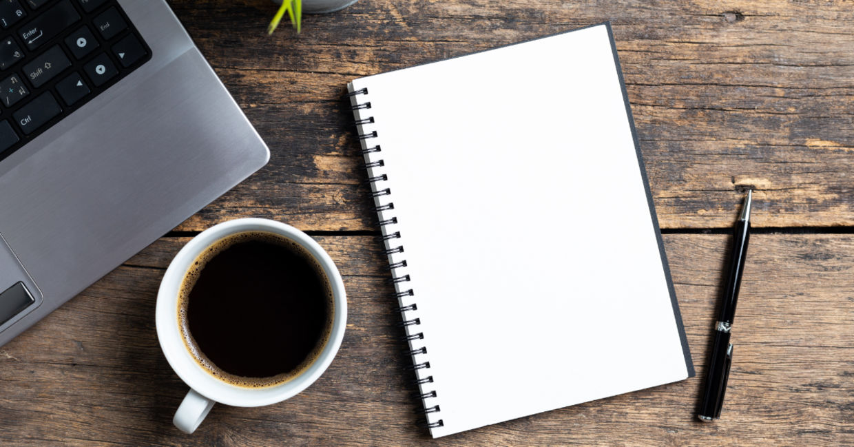 An empty notebook and a computer. An empty notebook and a computer.