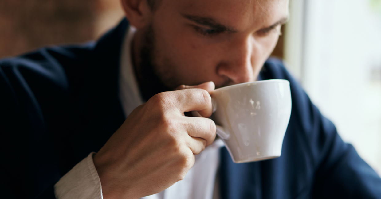 Portrait of a man enjoying a warm beverage in a porcelain cup. Portrait of a man enjoying a warm beverage in a porcelain cup.