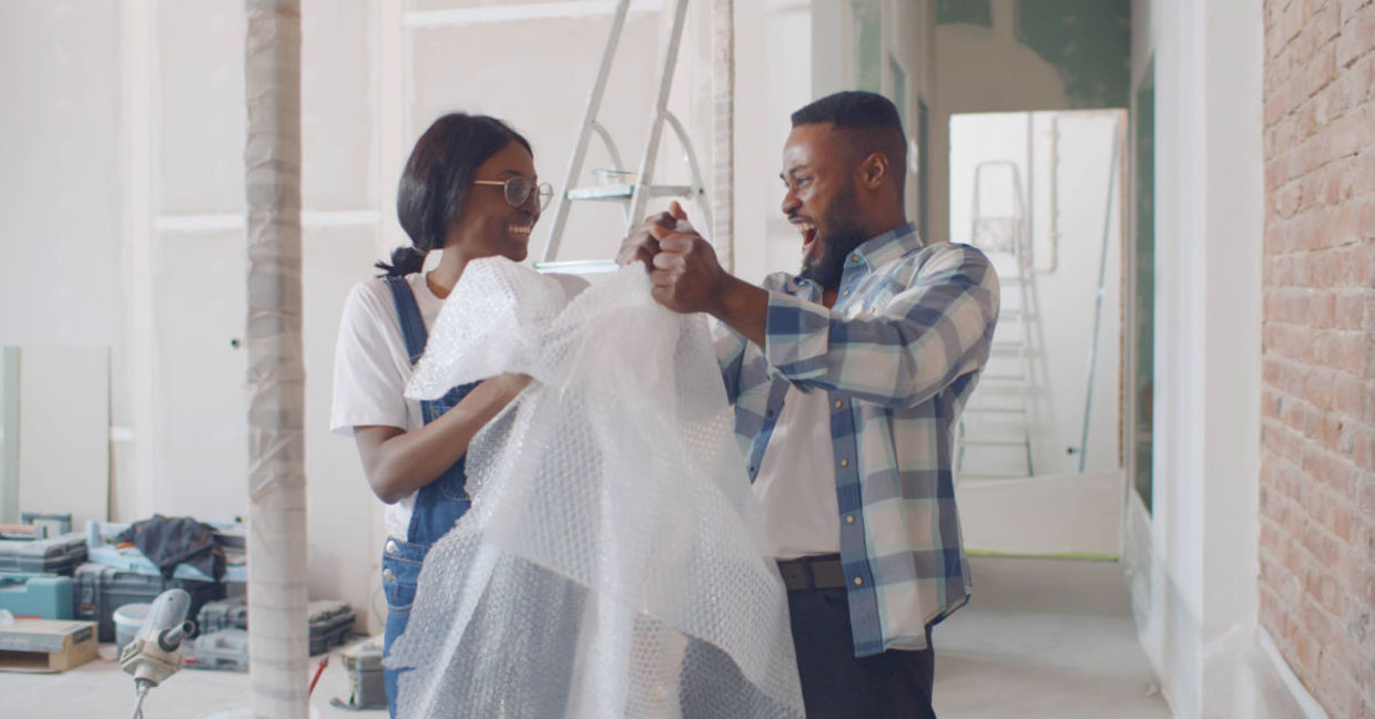 Happy couple having fun with bubble wrap. Happy couple having fun with bubble wrap.