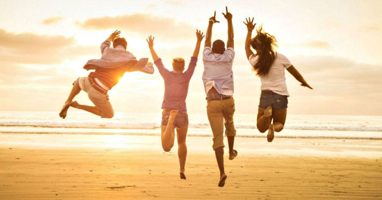 A group of friends jump for joy on the beach. A group of friends jump for joy on the beach.