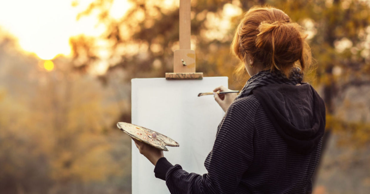 A woman enjoying her painting hobby and taking in the beautiful landscape A woman enjoying her painting hobby and taking in the beautiful landscape