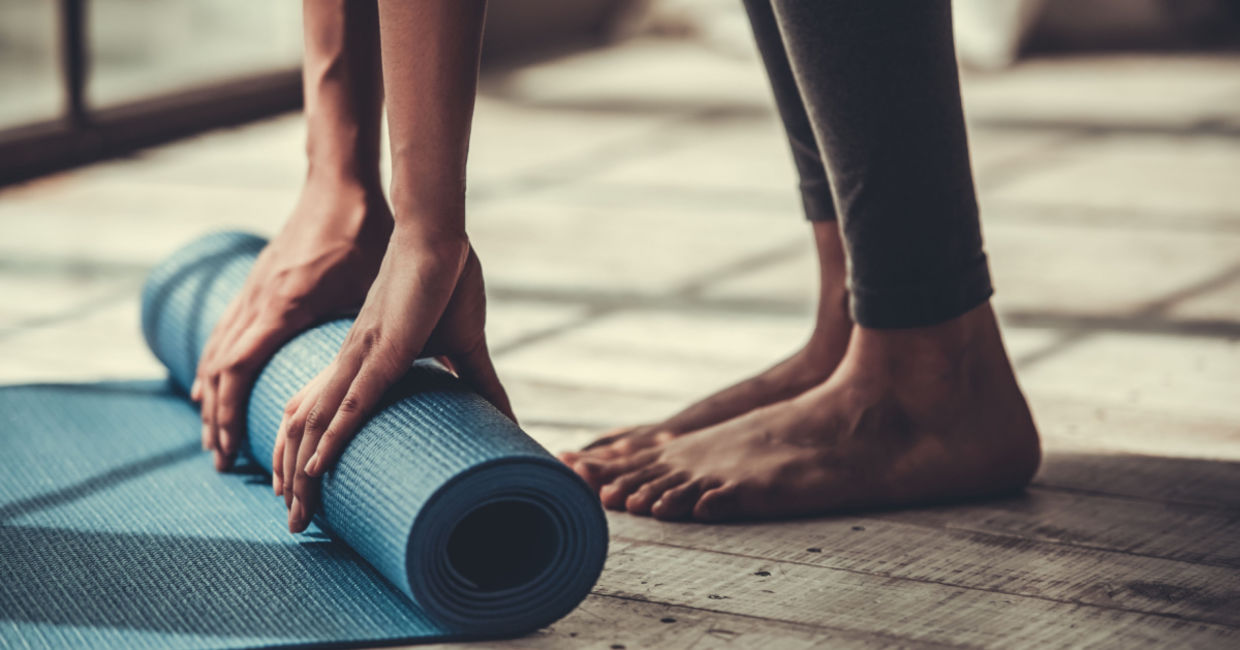 Man rolling out his yoga mat. Man rolling out his yoga mat.