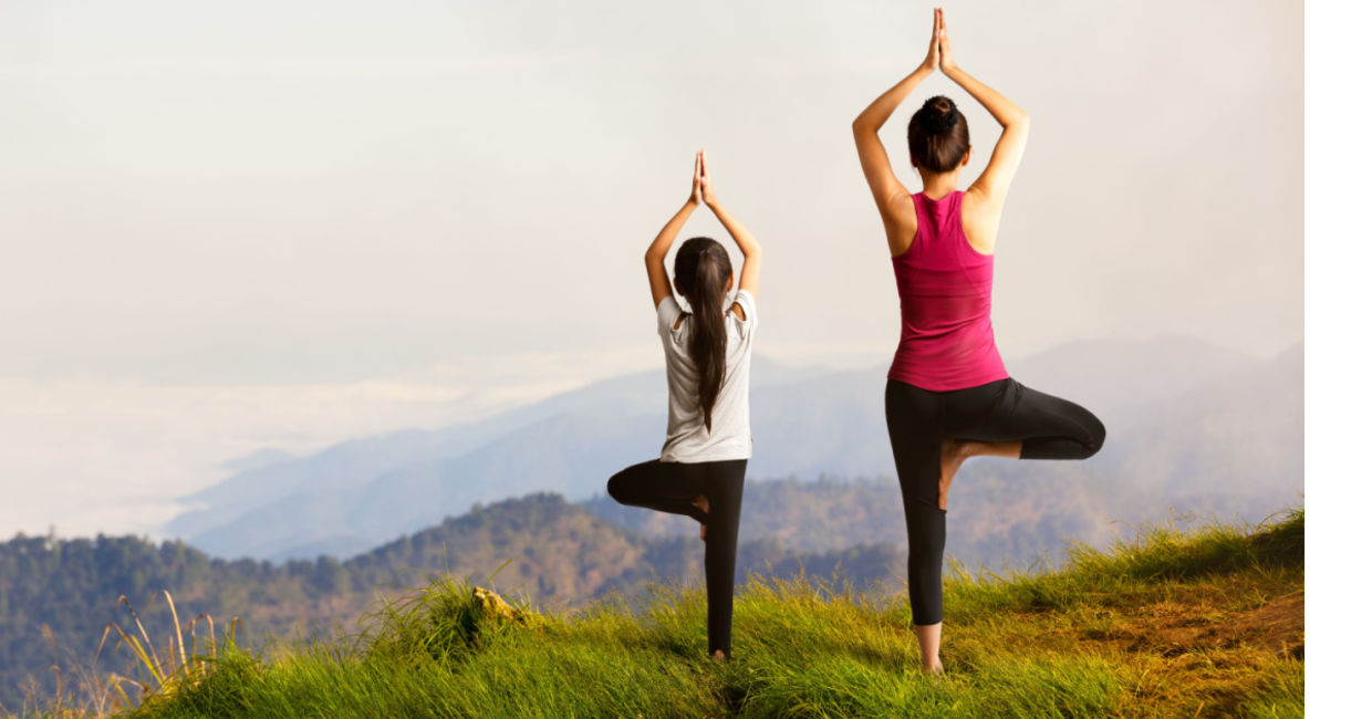 Mother and daughter practicing the tree pose. Mother and daughter practicing the tree pose.