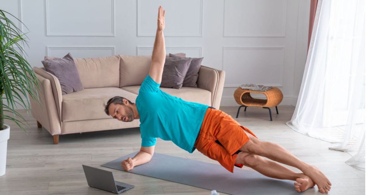 A man doing the side plank pose in a guided yoga session. A man doing the side plank pose in a guided yoga session.