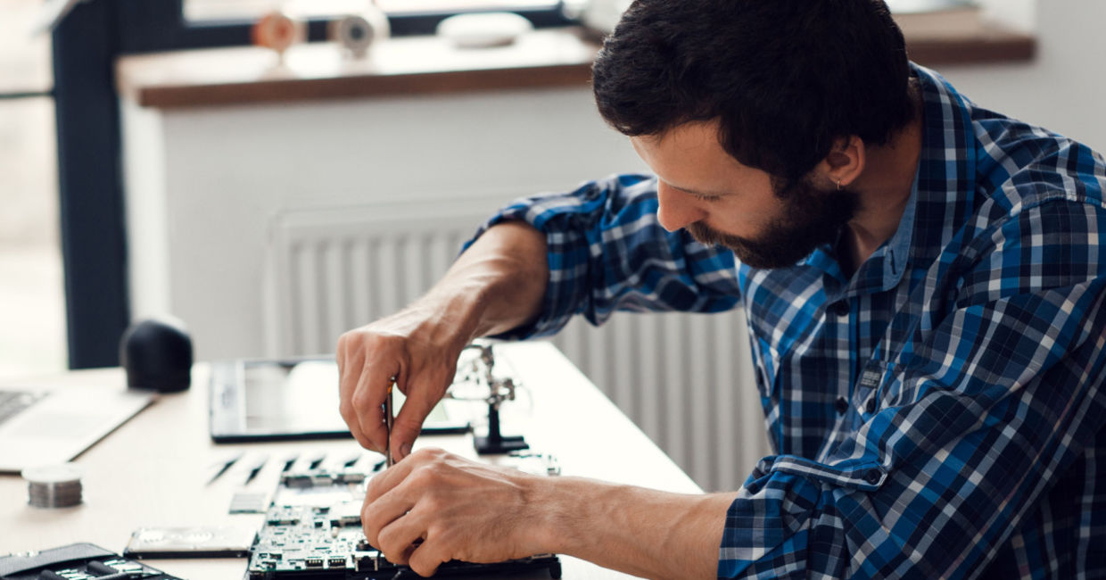 A man repairing a laptop computer. A man repairing a laptop computer.