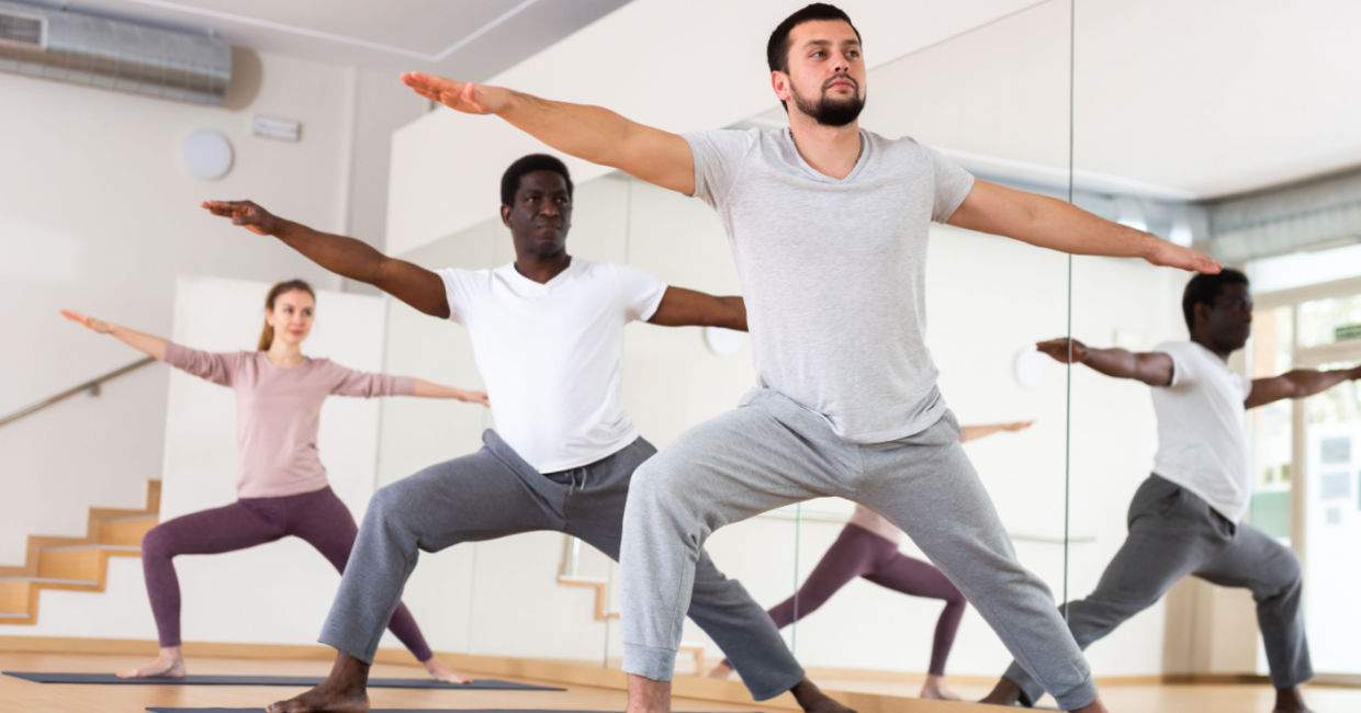 Yoga class in Warrior II pose. Yoga class in Warrior II pose.