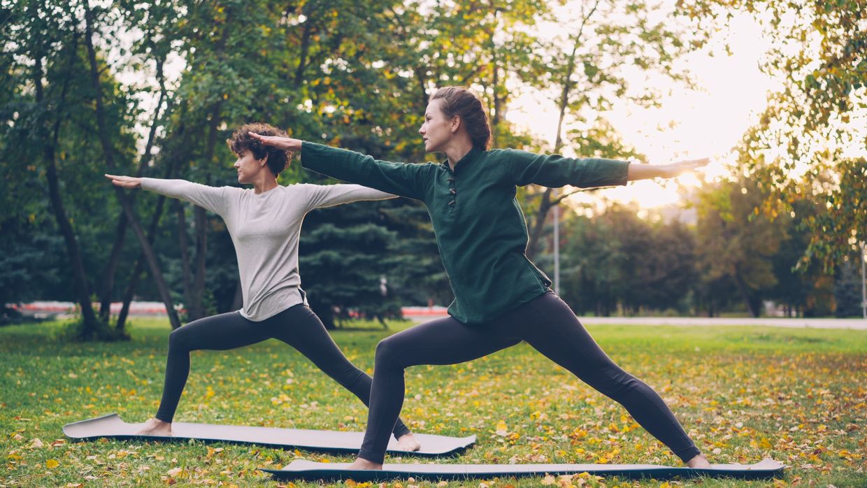 Women in the half moon yoga pose. Women in the half moon yoga pose.