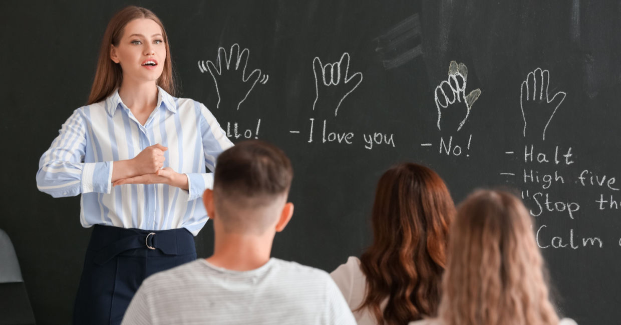 Teacher instructing a class on signing. Teacher instructing a class on signing.