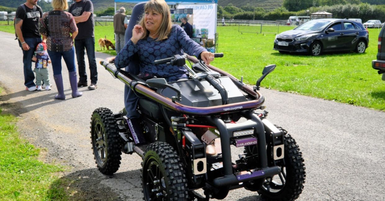 A woman using an all terrain motorized wheelchair. A woman using an all terrain motorized wheelchair.