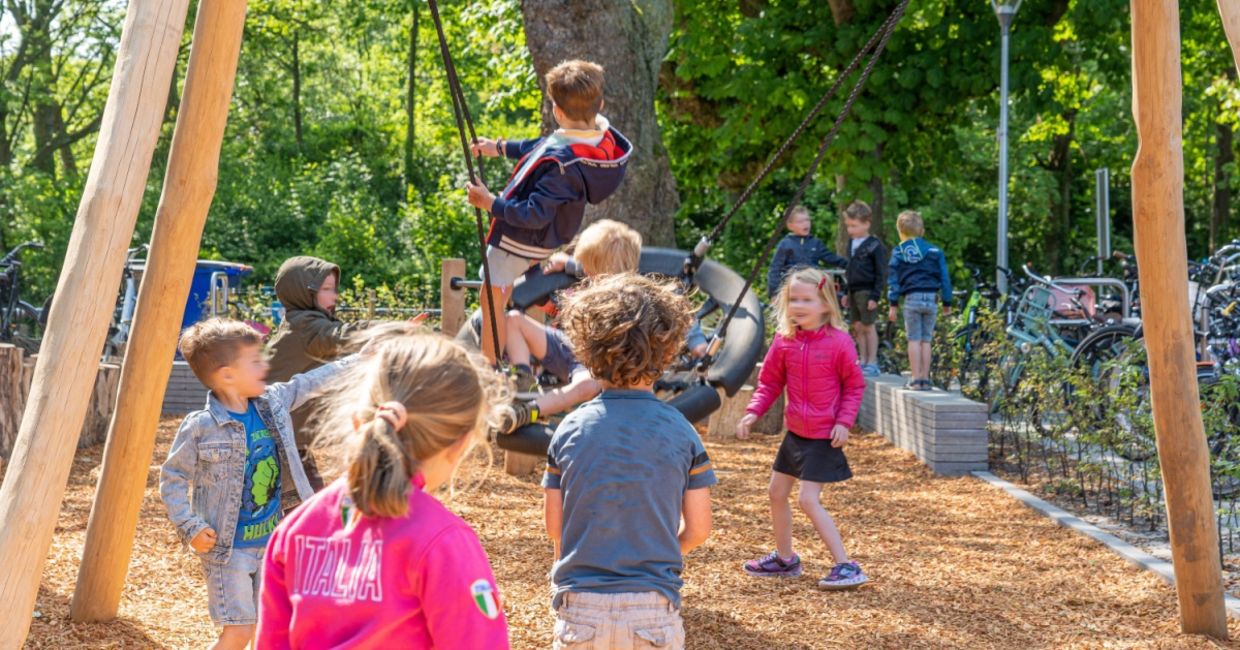 Elementary school children play outside in a playground with plenty of greenery. Elementary school children play outside in a playground with plenty of greenery.